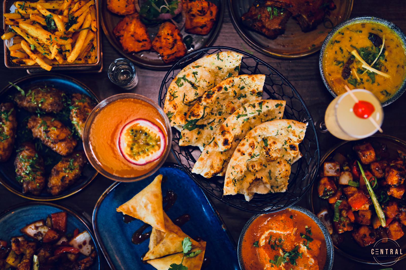 A spread of Indian dishes, naan and cocktails at Central
