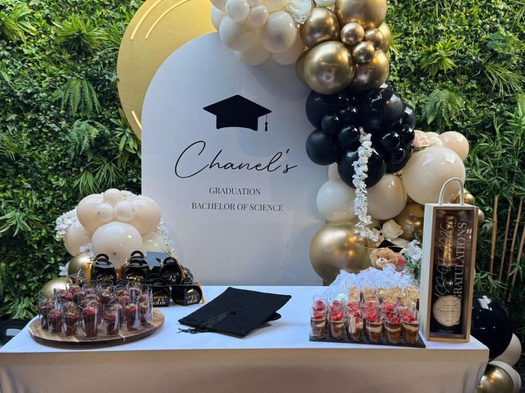 A graduation party set up at Central with a balloon arch, dessert table and champagne